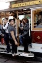 People commuting on a historic San Francisco cable car during the day.